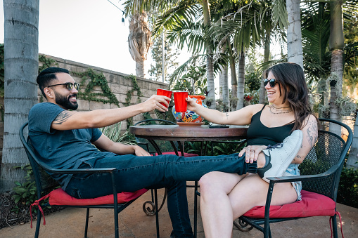 Couple Clinking Red Solo Cups At Barbecue Party