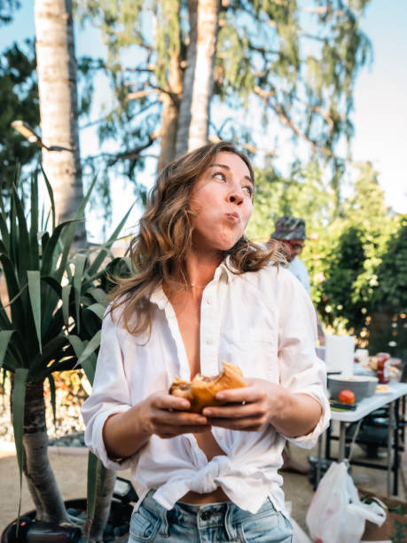 Woman Looking To The Side With Cheeseburger In Her Hand