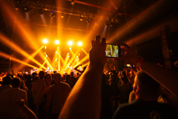 istock Hands holding phone and making photos on the concert. 1599182820