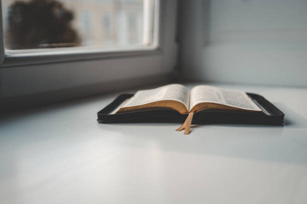 istock Open bible on windowsill, city view, morning prayer 1599207123