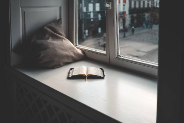 istock Open bible on windowsill, city view, morning prayer 1599207124