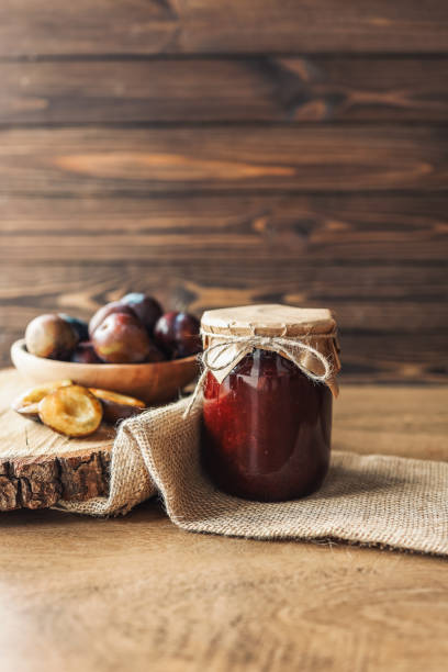 Jar of plum jam with craft decor