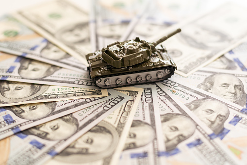 Military tank, American dollar bills. Concept: military and financial assistance to Ukraine, high arms costs, arms supplies from America. High quality photo