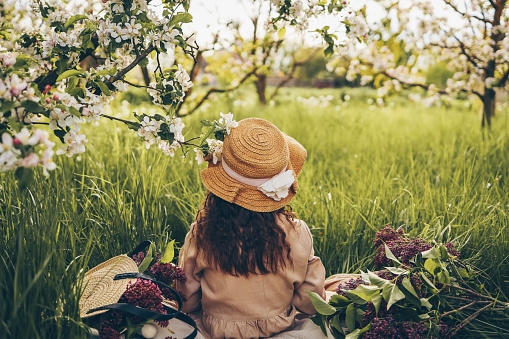 Little girl in a hat in the garden at a picnic.