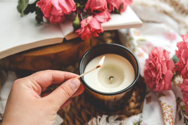 allumette à la main allume une bougie, photo esthétique - bougie parfumée photos et images de collection