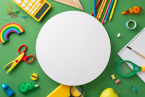 Eye-catching top-down view capturing the essence of elementary school education. Featuring a green chalkboard adorned with colorful school supplies, accompanied by copy-space for text or ads