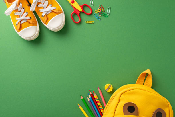 istock Learning tools galore: Top-down view of green chalkboard setting arranged with assortment of colorful school supplies, a kid's backpack, and sneakers. Ample space for text or educational advertising 1599298890