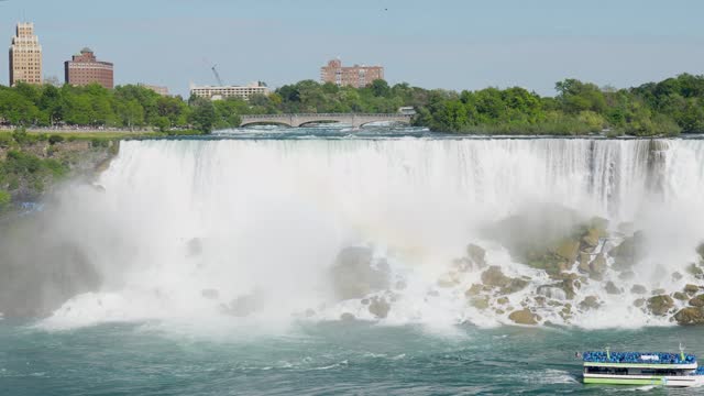 View of Niagara Falls tour boat on the Niagara river heading to Horseshoe Falls with a lot of mist from Canada