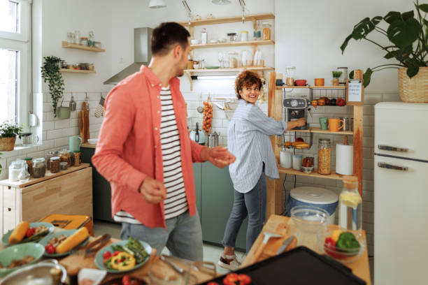 istock Young couple in kitchen together, making meal with vegetables 1599452873