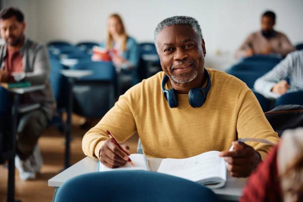 istock Smiling black senior man learning during adult education course and looking at camera. 1599474755