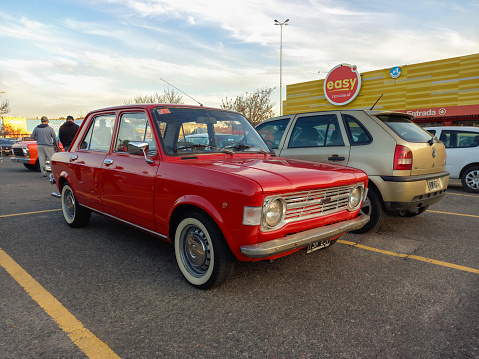 Buenos Aires, Argentina - May 28, 2023: Shot of an old red 1970s Fiat 128 sedan four door in a classic car show at a parking lot.