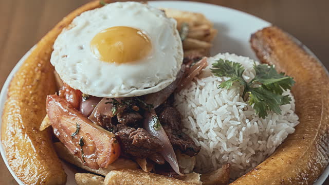 Peruvian food Lomo Saltado (Peruvian Stir-Fried Beef) with french fries, plantain and egg