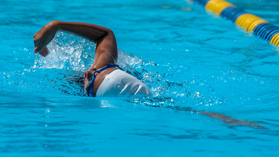 Shot of a male swimmer doing the butterfly stroke toward the camera