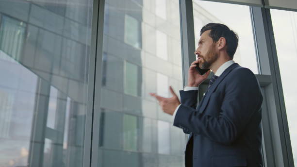 istock Serious boss talking mobile at office close up. Stressed manager speaking phone. 1599688627