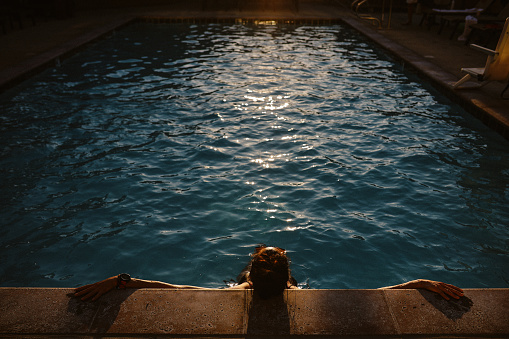 Woman relaxing in the pool, spending an easy afternoon.