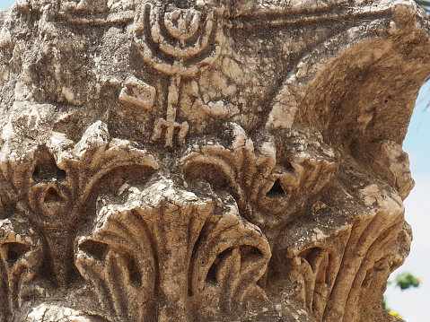 Beautiful carvings in a capital recovered from the synagogue in Capernaum, Israel by the Sea of Galilee.  This capital has a menorah toward the top.