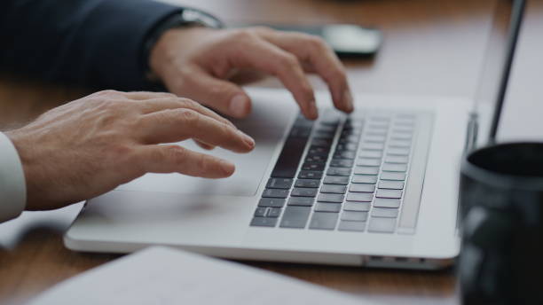 istock Man hands using touchpad on laptop typing documents at company office close up 1599740602