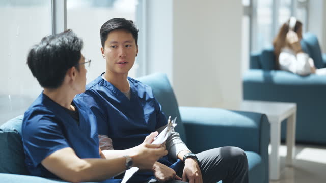 Asian Chinese male doctor and surgeon discussion on patient medical record