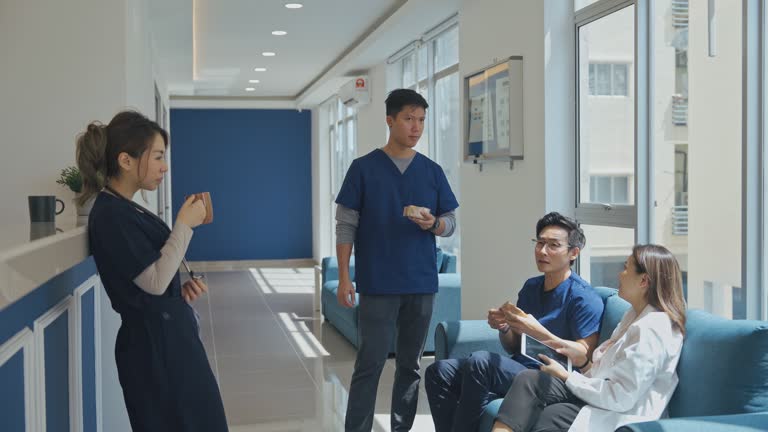 Asian Chinese doctors and nurses enjoying tea break in corridor