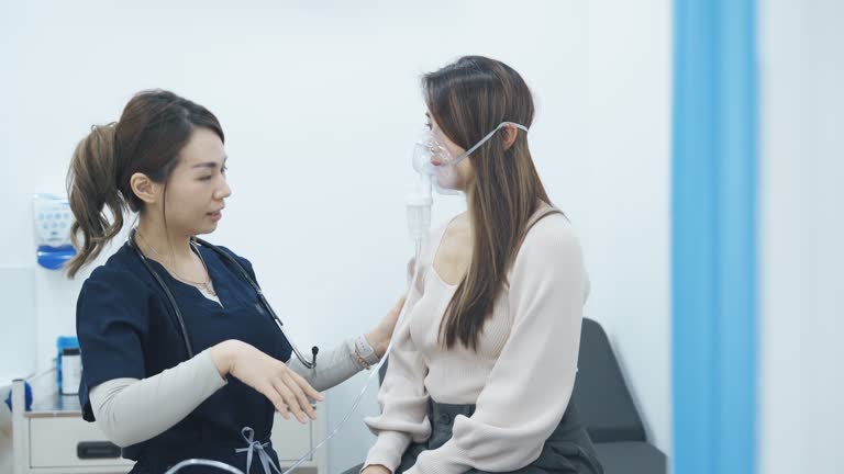 Female Doctor giving medical oxygen to her patient in medical examination room