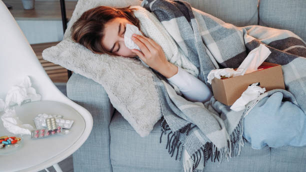 istock Home flu runny nose symptom suffering woman laying 1599869295