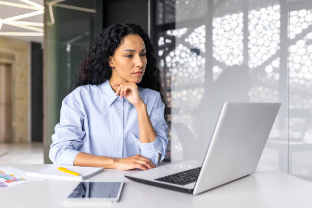 istock Beautiful indian woman programmer web developer focused and confident working on laptop writing code programming business woman worker in modern office working in casual clothes. 1599879648