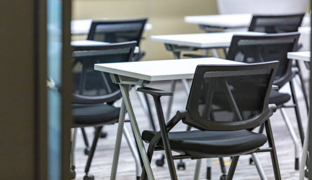 istock Neat chairs and multimedia screens in modern style training classroom 1599988496