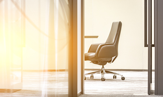 Open glass door in modern style office with leather armchair