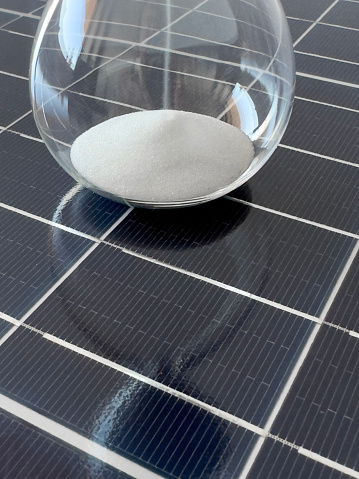 Close up photo of an hourglass on a solar cell panel