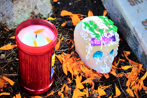 Ofrenda del dia de muertos el primero de noviembre en tumbas del panteon en ciudad de México, calaveras de azucar, frutas y flores