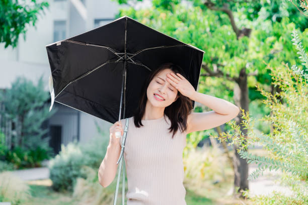 Young woman walking outside with a sun umbrella stock photo