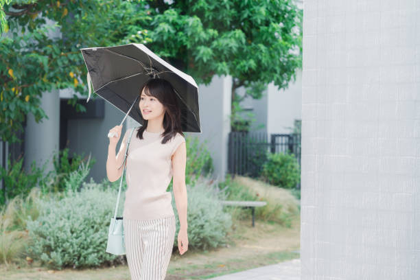 Young woman in black dress standing on street in rainy city