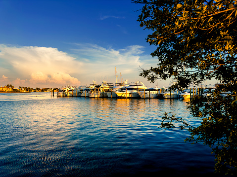 Oranges and pinks highlight all the boats, water and sky in Oceanside Harbor, near Carlsbad, California in Southern California.