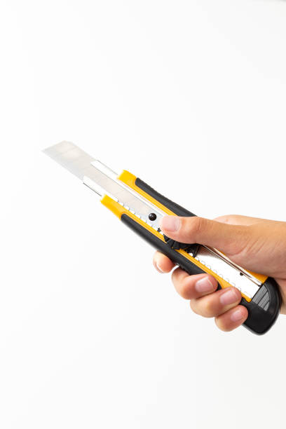 istock Hand holding utility knife on white background. 1600123209