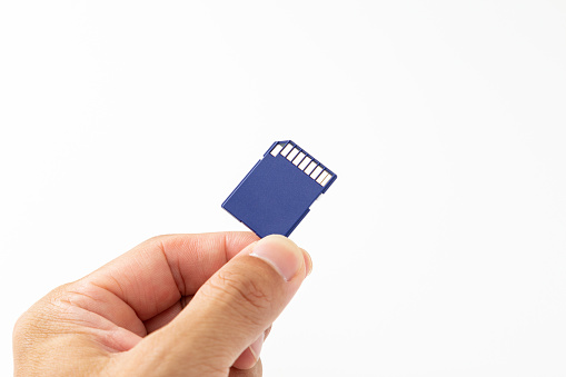 Hand holding SD card on white background.