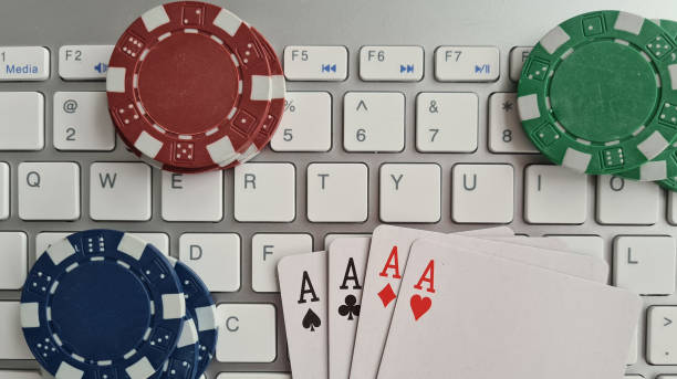 istock Computer keyboard four aces and cards casino chips and dice closeup 1600125062