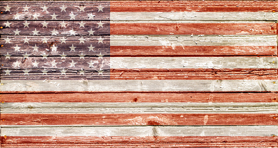 U.S. flag with the texture of rough wooden planks. U.S. flag on old rough boards.