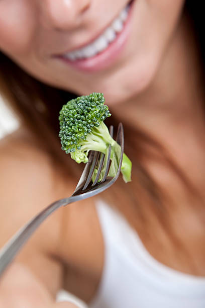 istock Woman eat broccoli 160017928