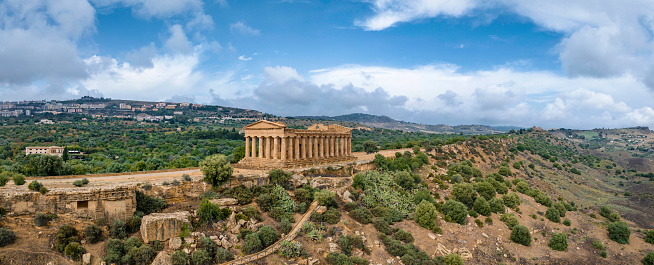Majestic ancient greek Temple of Concordia in Agrigento on top of the hill under blue summer skyscape. Aerial Drone XXXL Stitched Concordia Temple Panorama. Valley of the Temples in Agrigento City. Temple of Concordia, Valley of the Temples, Agrigento, Sicily Island, Southern Europe, Europe.