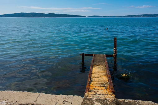 A rusted old landing stage on the Adriatic coast of Croatia at Kastel Kambelovac in Kastela. Late spring