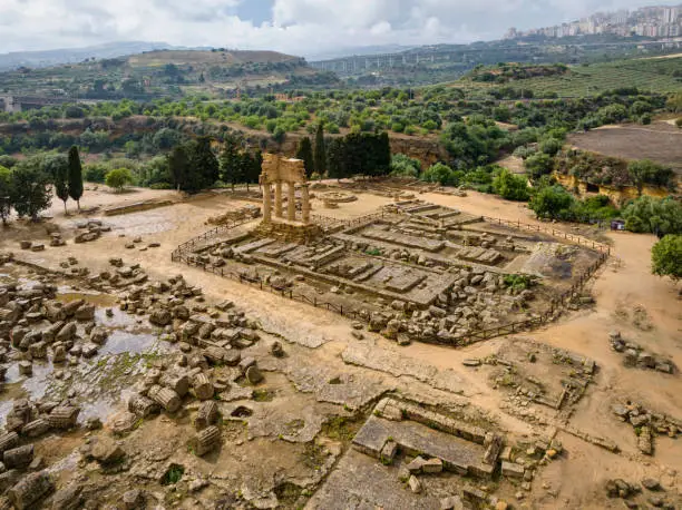 Majestic ancient Remnants of the Temple of Castor and Pollux or Temple of the Dioscuri in Agrigento in summer. Aerial Drone Point of View to the Remnants of the Temple of Castor and Pollux View. The Temple of the Dioscuri (Castor and Pollux) in Agrigento was built in the middle of the 5th century BCE. The preserved four columns were made in the Doric order. Dioscuri were twins who were worshipped in ancient Greece and Rome. According to Greek mythology, they took part in the Argonaut’s expedition. Valley of the Temples in Agrigento City. Temple of Castor and Pollux - Temple of the Dioscuri, Valley of the Temples, Agrigento, Sicily Island, Southern Europe, Europe.