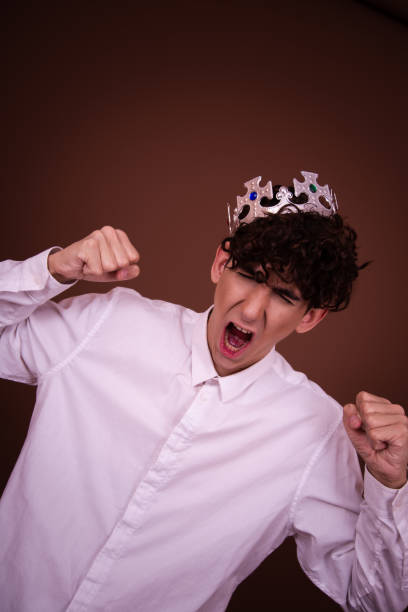 istock Young funny guy with british flag posing on brown background. 1600254134