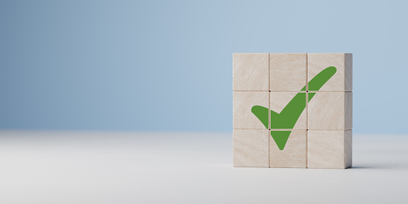 Green tick. Goals achievement and business success. Task completion. Ethical corporate. Do right thing. Quality symbol. Wooden cube with green checkmark icon.