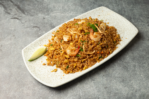 Mixed Fried Rice with chicken, egg, crab meat, prawn and shrimp served in dish isolated isolated on background top view of bangladesh food