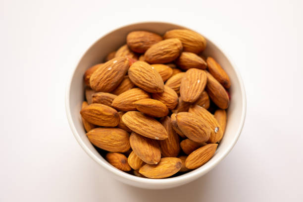 istock bowl with tasty almonds on white background, top view 1600295178