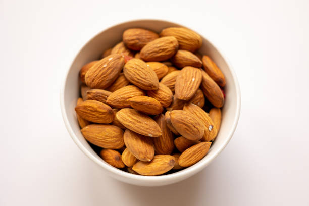 istock bowl with tasty almonds on white background, top view 1600295194