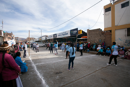 Puno, Peru 1st January, 2023: Local women playing volleyball in front of a Food Market in Puno.