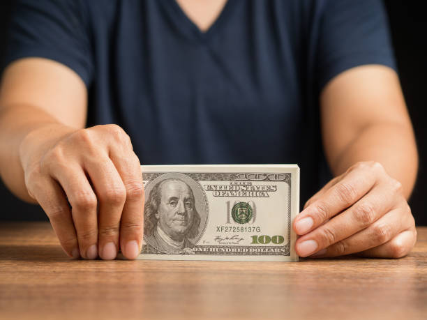 istock Man in casual holding US banknotes while standing in the office 1600326202