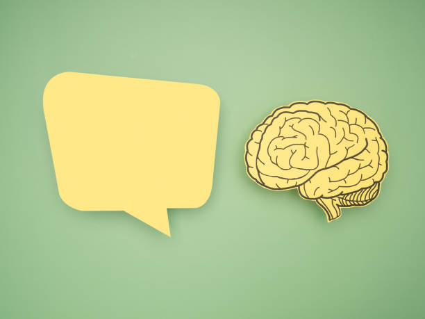 istock Yellow speech bubble and brain shape made from paper on a green background 1600328380