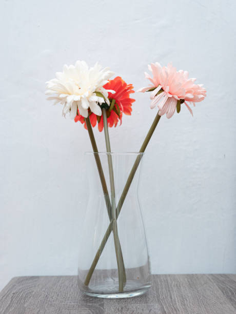 istock artificial daisy flower in clear glass vase 1600355518